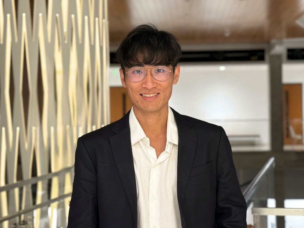 Professor Kent Zheng in a suit, smiling at the camera